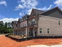 A row of newly constructed townhouses with brick exteriors under a blue sky at 3232 Cyrus Creek Dr, Kennesaw, GA 30152