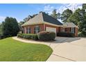 Well-maintained brick home with an attached garage, manicured landscaping, and a long driveway at 5831 Wembley Dr, Douglasville, GA 30135