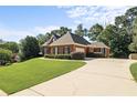 Well-maintained brick home with an attached garage, manicured landscaping, and a long driveway at 5831 Wembley Dr, Douglasville, GA 30135