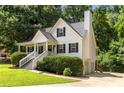 Angle view of the attractive home with a side entry garage, chimney, and mature trees at 6280 Autry Mill Rd, Cumming, GA 30028