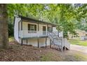 Exterior view of home featuring welcoming porch and mature trees at 6441 Michell Way, Douglasville, GA 30135