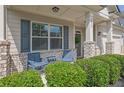 Charming front porch area with seating, brick accents, and manicured landscaping at 3940 Frasier Dr, Cumming, GA 30028