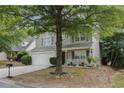 Attractive two-story home featuring gray siding, white trim, a two-car garage and mature trees at 3347 Sable Run Rd, Atlanta, GA 30349