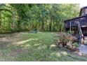 Expansive backyard featuring mature trees, open green space, and outdoor seating area for entertaining at 3470 Hill Ln, Acworth, GA 30102