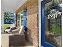 Cozy front porch featuring comfortable seating, brick facade with blue shutters, and stylish front door with decorative wreath at 109 Hale View Cir, Canton, GA 30114