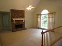 Spacious living room featuring a stone fireplace, vaulted ceilings, and large windows offering ample natural light at 5820 Elm Tree Dr, Buford, GA 30518