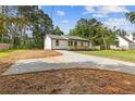Charming single-story home featuring a lovely front porch, a well-maintained lawn and a long concrete driveway at 2310 Whitehead Place Dr, Suwanee, GA 30024
