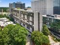 View of high-rise apartment building nestled among lush green trees in the city at 145 15Th Ne St # 1430, Atlanta, GA 30309