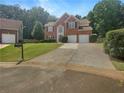 Beautiful two-story brick home with blue shutters, a manicured lawn and a long driveway at 4133 Rosedown Nw Ct, Kennesaw, GA 30144