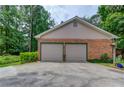 Spacious two-car brick garage with neutral doors, surrounded by greenery and a concrete driveway at 2291 Smokehouse Path, Lawrenceville, GA 30044