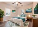 Bright bedroom with a comfortable bed, stylish decor, and natural light from two windows at 7880 Rivertown Rd, Fairburn, GA 30213