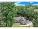 Scenic aerial shot of a charming home with lush backyard, nestled among dense trees and a winding driveway at 2105 Huntington Hills Trce, Buford, GA 30519