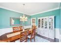 Charming dining room features a statement chandelier, turquoise walls, and beautiful hardwood floors at 4365 Mantle Ridge Dr, Cumming, GA 30041