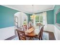 Bright dining room showcases hardwood floors, a stylish chandelier, and an arched doorway to the foyer at 4365 Mantle Ridge Dr, Cumming, GA 30041