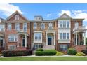 Attractive townhome featuring a mix of brick and stone facade, complemented by lush green lawn and manicured landscaping at 4874 Seldon Se Way, Smyrna, GA 30080