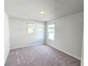 Clean, carpeted bedroom with two windows offering natural light, ready for your personal touch at 2665 Mourning Dove Drive(Lot 51), Grayson, GA 30017