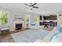 Open living room with a fireplace, ceiling fan, and an adjacent kitchen with a breakfast bar at 432 Providence Walk St, Canton, GA 30114