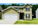 Two-story home with green siding, two-car garage, and a well-manicured lawn and landscape at 4417 Belcamp Rd, Fairburn, GA 30213
