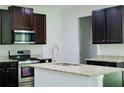Kitchen with stainless steel appliances, granite countertops, and dark brown cabinets at 4417 Belcamp Rd, Fairburn, GA 30213