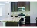 Kitchen with stainless steel appliances, granite countertops, and dark brown cabinets at 4417 Belcamp Rd, Fairburn, GA 30213