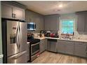 Updated kitchen with stainless steel appliances, gray cabinets, and ample counter space at 2433 Robin Ridge Dr, Dacula, GA 30019