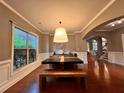 Spacious dining room with modern light fixture and a large window providing natural light, bench seating and hardwood floor at 2532 Gloster Mill Drive Southwest, Lawrenceville, GA 30044
