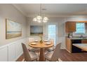 Cozy dining area features a modern chandelier, wainscoting, and views of the backyard at 5341 Terrytown Ln, Lithonia, GA 30038