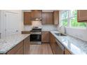 Modern kitchen featuring granite countertops, stainless steel appliances, and wood look floors at 334 Bloomfield Cir, Canton, GA 30114