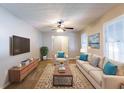 Bright living room featuring neutral walls, plush seating, a ceiling fan, and windows that flood the room with light at 1105 Buckhurst Dr, Atlanta, GA 30349