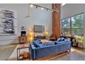 Bright living room with large window, exposed brick wall, and comfortable blue sofa at 195 Arizona Ne Ave # 199, Atlanta, GA 30307