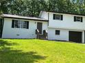 A charming two-story home with freshly painted brick and a lush green lawn in a wooded area at 3800 Leisure Ln, Atlanta, GA 30349