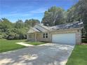 A beautiful single-Gathering home boasting a well-maintained lawn, attached garage, and a classic brick facade at 243 Roxbury Dr, Riverdale, GA 30274
