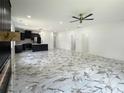 A spacious open-concept living room featuring stylish tile floors and a modern kitchen in the background at 243 Roxbury Dr, Riverdale, GA 30274