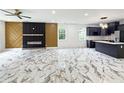 Bright living space features modern fireplace, herringbone accent wall, gorgeous floors, and kitchen with island at 243 Roxbury Dr, Riverdale, GA 30274