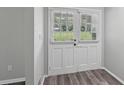 Bright entryway with white double doors and light wood grain vinyl plank flooring at 2849 Snapfinger Rd, Decatur, GA 30034