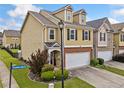 Side view of a tan townhome showcasing the corner lot and well-maintained landscaping at 44 Providence Oak Ct, Lawrenceville, GA 30046