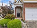 Close-up of the front entrance with a brick facade, a black door, and manicured landscaping at 44 Providence Oak Ct, Lawrenceville, GA 30046
