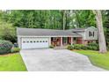 Home exterior with a two-car garage, manicured lawn, and brick accents create an inviting curb appeal at 595 Glenforest Rd, Sandy Springs, GA 30328