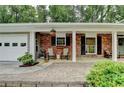Charming front porch with brick flooring and walls, furnished with chairs, perfect for relaxing outdoors at 595 Glenforest Rd, Sandy Springs, GA 30328