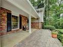 Inviting covered front porch area featuring brick accents, seating and great natural light at 595 Glenforest Rd, Sandy Springs, GA 30328