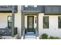 Elegant townhouse entrance featuring white painted brick, black trim, and a covered porch at 908 Catamaran Ct, Alpharetta, GA 30005