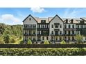 View of luxury townhomes with black framed windows, painted brick and beautifully manicured landscaping at 908 Catamaran Ct, Alpharetta, GA 30005