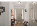 Welcoming foyer with wood floors, neutral walls, decorative mirror, and bench seating at 1889 Raegan Way, Lawrenceville, GA 30043