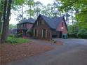 Side view of a red brick two-story home with an attached garage and driveway at 5741 Wolf Laurel Ln, Lilburn, GA 30047