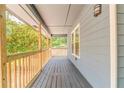 Inviting covered front porch with wood railings and gray painted wood floor at 7074 Babbling Brook Dr, Jonesboro, GA 30236