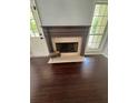 Cozy living room with hardwood floors and a stylish fireplace with decorative mantle at 955 Tributary Way, Dacula, GA 30019