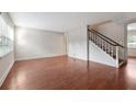 Empty living room features hardwood floors, a staircase, and large windows at 290 Lakemoore Ne Dr # C, Atlanta, GA 30342