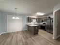 Eat-in kitchen features granite countertops, stainless steel appliances, wood-look floors, and pendant lighting at 5538 Pineridge Ct, Forest Park, GA 30297