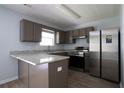 Bright kitchen featuring stainless steel refrigerator, granite counters, and updated cabinets at 5538 Pineridge Ct, Forest Park, GA 30297