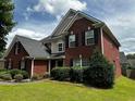 Charming two-story home with lush green lawn, mature trees, and well-maintained landscaping features at 1498 Park Knoll Trl, Lawrenceville, GA 30043